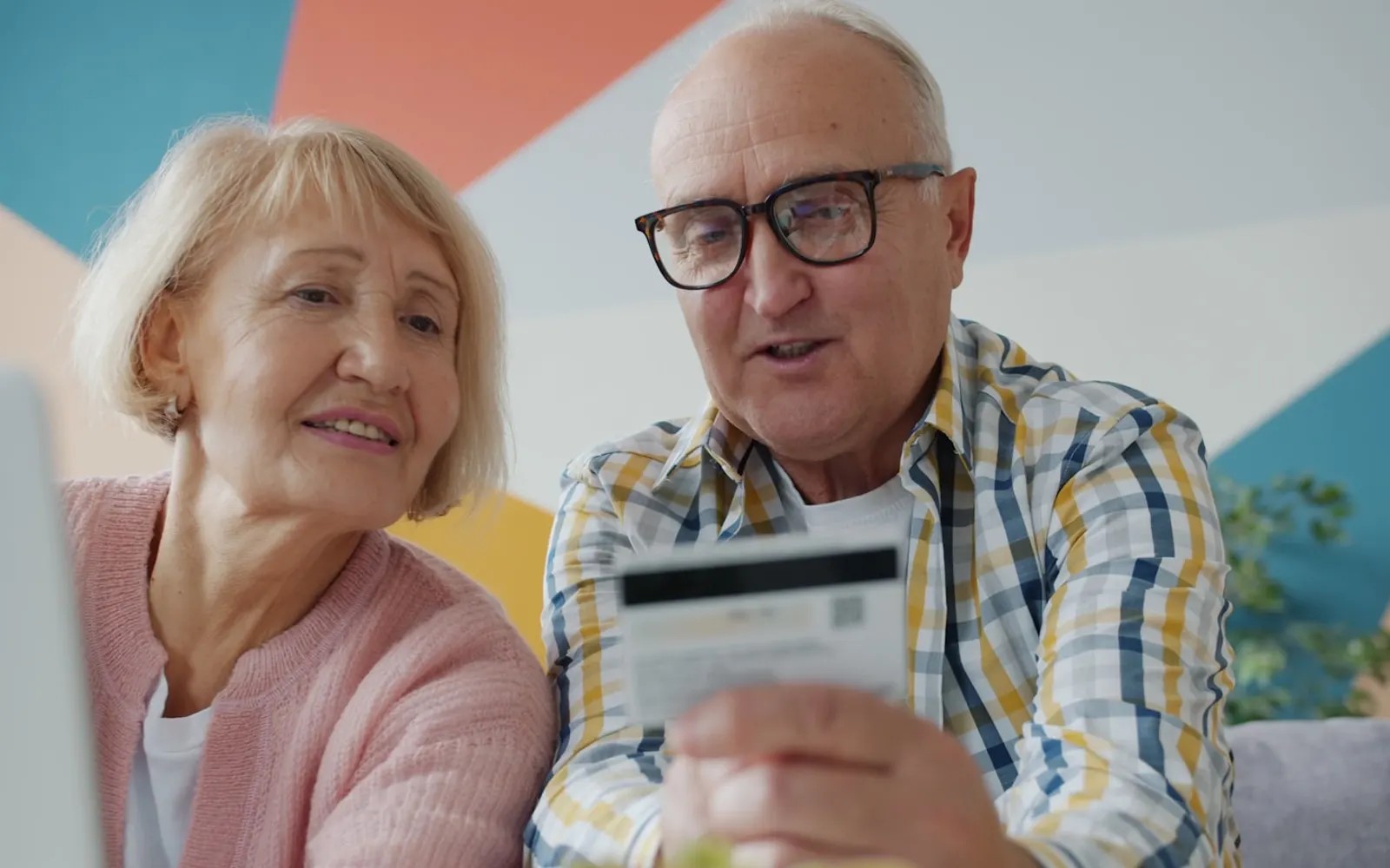 Couple planning their savings with a card and laptop